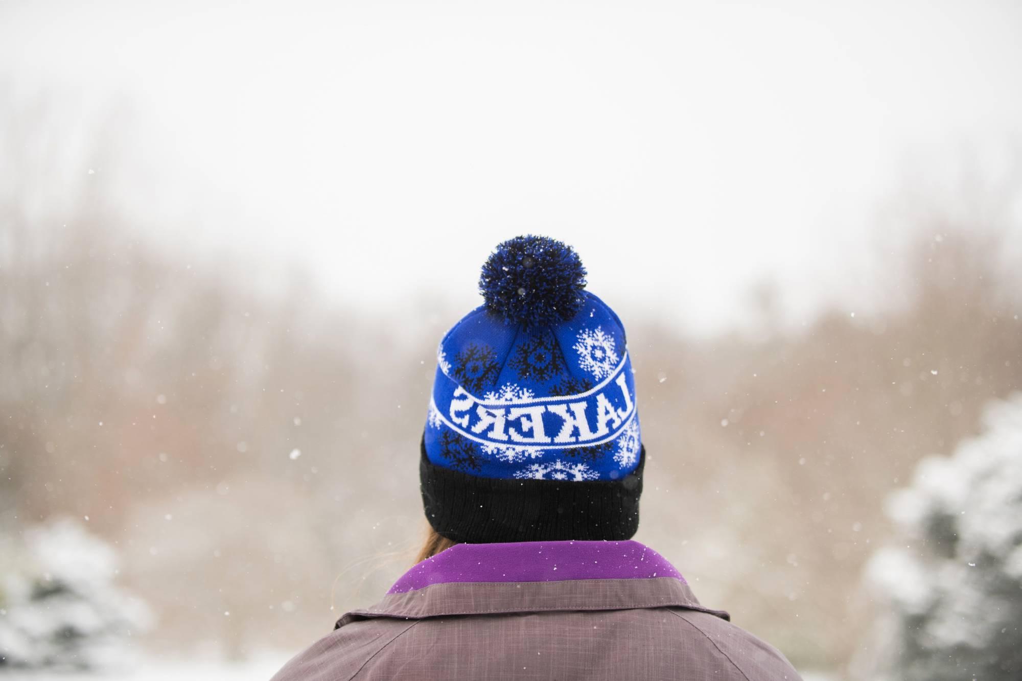 GVSU Student snowshoeing with a GVSU Lakers winter hat on head